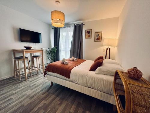 une chambre avec un lit, un bureau et une télévision dans l'établissement Le TerraRosa, studio à Rennes, à Chantepie