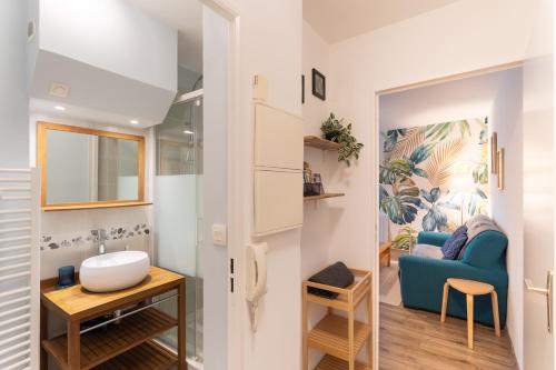 La salle de bains est pourvue d'un canapé bleu et d'un fauteuil bleu. dans l'établissement La Canopée Urbaine - Apt centre-ville avec parking, à Rennes