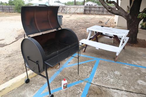 a grill and a bench and a picnic table at Hotel Dilley Grand in Dilley