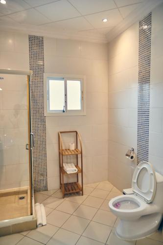 a bathroom with a toilet and a shower at Guest Wharf - Centre Ville in Pointe-Noire