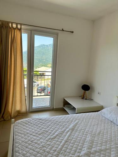 a bedroom with a bed and a large window at Kronos in Budva