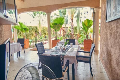 a patio with a table and chairs and plants at Guest Wharf - Centre Ville in Pointe-Noire