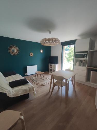 un salon avec une table et un canapé dans l'établissement Appartement à la campagne, à Laveneas