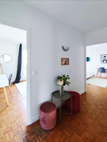 un salon blanc avec une table et un tabouret dans l'établissement Flexliving - room - Villon, à Paris
