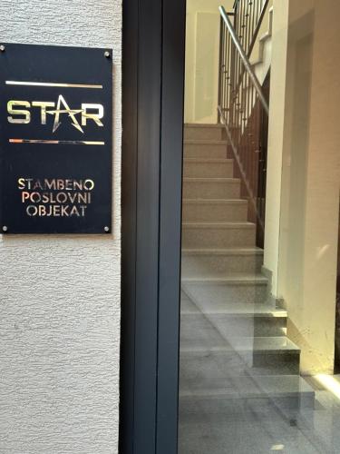 a sign on the side of a building with a staircase at Star apartman 3 in Novi Pazar
