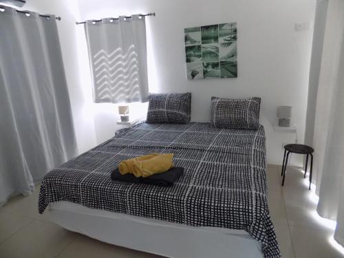 a bedroom with a bed with a yellow shirt on it at Favvidea in Jan Thiel