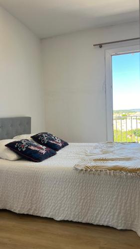 - un lit avec deux oreillers dans une chambre dotée d'une fenêtre dans l'établissement Soraya 16, à Port-la-Nouvelle