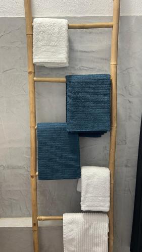 - un porte-serviettes en bambou avec 4 serviettes de couleur différente dans l'établissement Soraya 16, à Port-la-Nouvelle