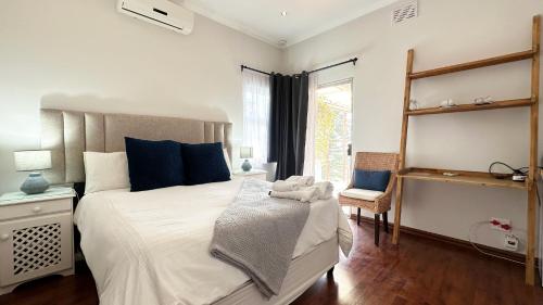 a bedroom with a large white bed with blue pillows at Anchor Bay Workation in Cape Town