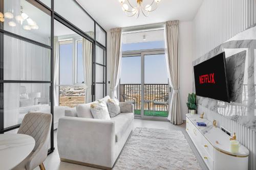 a living room with a white couch and a tv at Luxury Apt in Dubai Hills Burj Khalifa views in Dubai