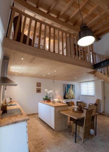 une cuisine et une salle à manger avec un plafond en bois dans l'établissement Charmant Atelier de la Fontaine, à Saint-Seurin-de-Prats