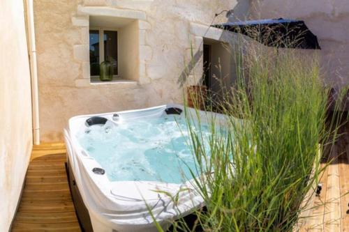 une baignoire jacuzzi dans l'angle d'une salle de bains dans l'établissement Charmant Atelier de la Fontaine, à Saint-Seurin-de-Prats