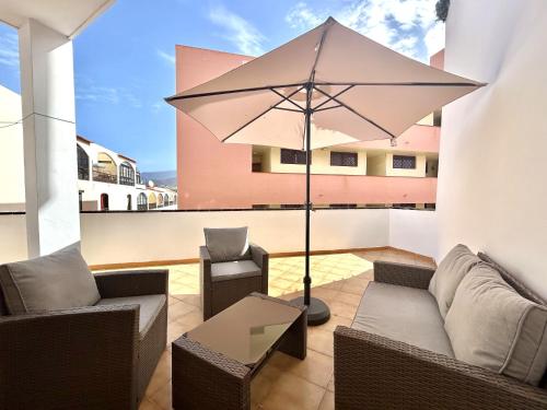a patio with a couch and an umbrella at Apt In Colina 2, Los Cristianos K105 in El Guincho