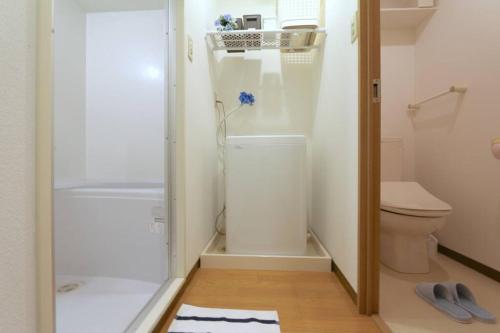 a small bathroom with a toilet and a shower at B3 Guest House ユニオン新大阪,新大阪,十三,梅田近く 長期滞在にも最適 in Osaka