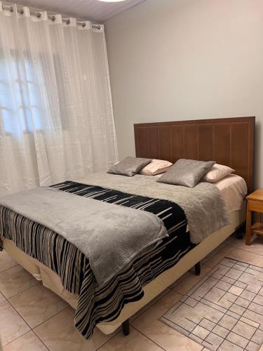 a bedroom with a bed and a window at Tranquilo e perto de tudo em SR in São Roque