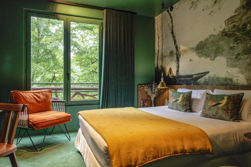 une chambre avec un grand lit et une fenêtre dans l'établissement Les Etangs de Corot, à Ville-dʼAvray