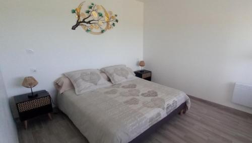 a bedroom with a bed and a clock on the wall at Les escargots du mont in Tanis