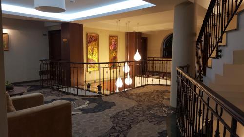 a hallway with a staircase with wrought iron railings at Hotel Miruna - New Belvedere in Poiana Brasov