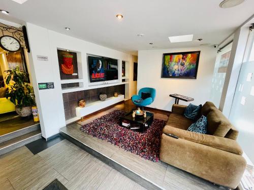 una sala de estar con un sofá y una silla en Hotel Santa Cruz Bogotá, en Bogotá