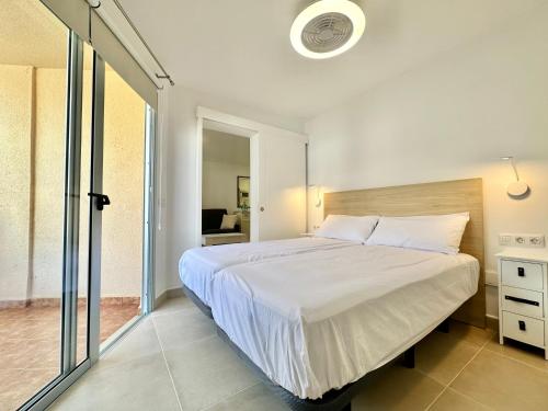 - une chambre avec un grand lit et une porte coulissante en verre dans l'établissement Daniela 203 - Adults Only -, à Puerto de la Cruz