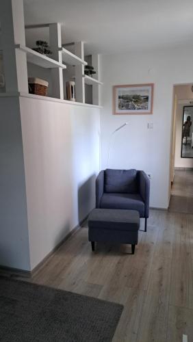 a living room with a blue chair and a couch at Apartmani i Sobe Kočiš in Bjelovar