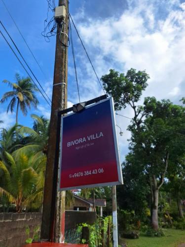 a sign hanging from a pole on a street at BIVORA Villa in Negombo