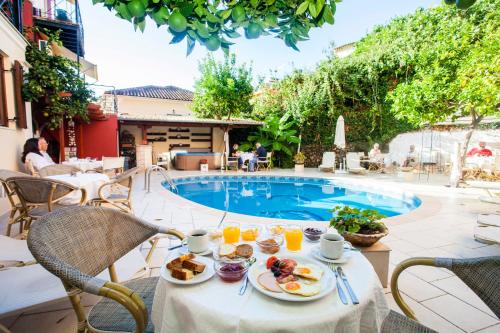a table with plates of food next to a swimming pool at Paradise Hotel in Parga