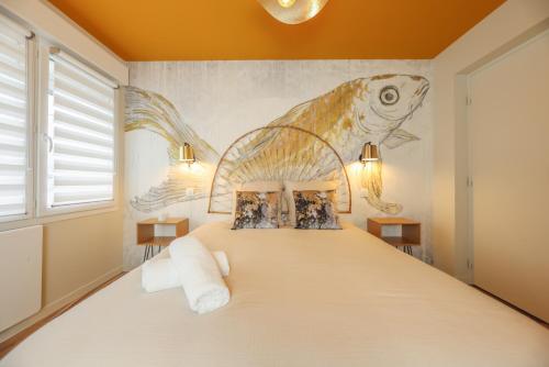 a bedroom with a bed with a fish mural on the wall at Le Coloré, Apt 90m2, 4 pers, Wimille proche Wimereux in Wimille