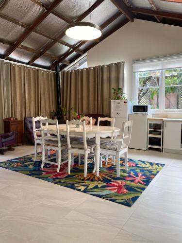 a dining room with a table and chairs on a rug at Silver Gum House in South Fremantle