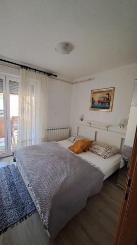 a bedroom with two beds and a window at Apartmani i Sobe Kočiš in Bjelovar