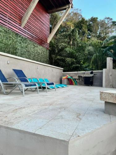 two blue lounge chairs sitting on a patio at Palm Luxury King Suite, Pool, ocean views, beach short walk West Bay West End in West Bay