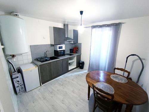 une cuisine avec une table en bois et une salle à manger dans l'établissement Le bon appart proche centre-ville, à Roanne