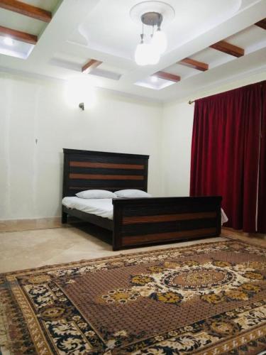 a bedroom with a bed and a red curtain at Bhurban Lodges in Murree