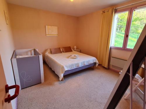 une petite chambre avec un lit et une fenêtre dans l'établissement Le Gîte de la Bourges, à Saint-Pierre-de-Colombier