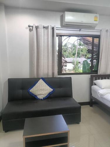 a living room with a couch and a window at Wasin House One Bedroom - Maenum in Mae Nam