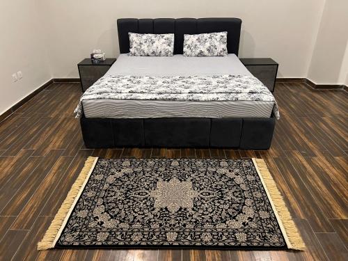a bed in a bedroom with a rug on the floor at The Shadow - Cozy 1BHK - Self Check In in Rawalpindi