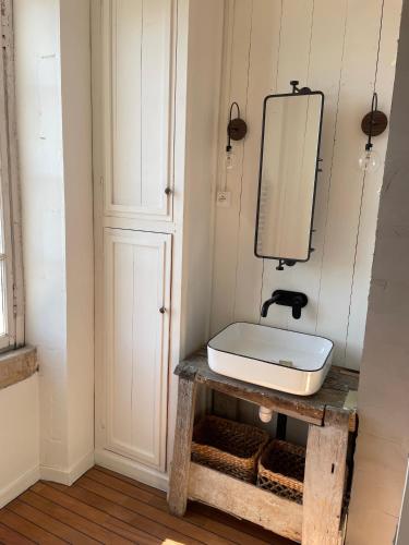 La salle de bains est pourvue d'un lavabo et d'un miroir sur une table. dans l'établissement Les Olivettes, à La Couarde-sur-Mer