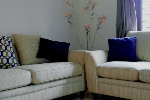 two chairs and a couch in a living room at Zealots Cyber Hills Villa, Kozhikode - Calicut in Kakkayam