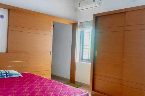 a bedroom with a bed and a large wooden closet at Zealots Cyber Hills Villa, Kozhikode - Calicut in Kakkayam