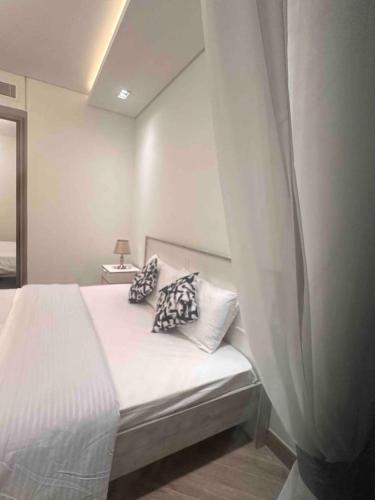 a bedroom with a bed with white sheets and pillows at High Floor Era View Tower City View in Manama