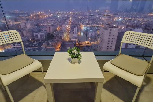 a table and two chairs with a view of a city at High Floor Era View Tower City View in Manama