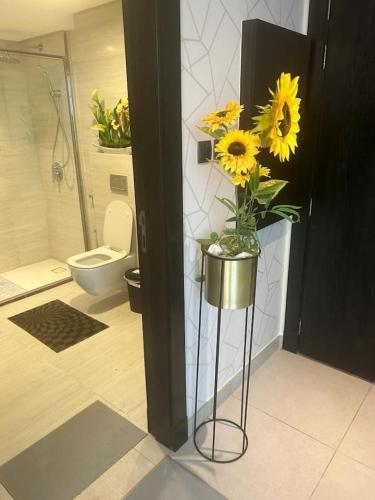 a bathroom with a vase with sunflowers in it at VIP Luxury Premium Apartment in Manama