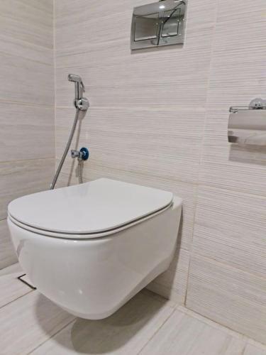 a bathroom with a white toilet in a room at High Floor Era View Tower City View in Manama