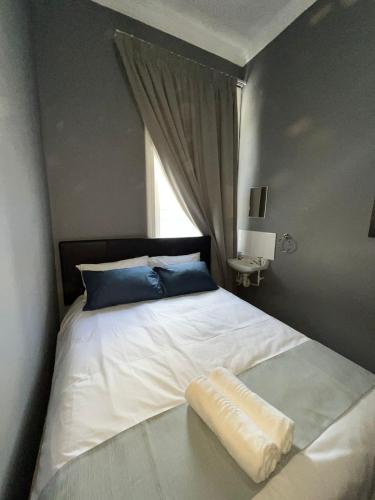 a bedroom with a bed with a pillow and a window at CapePod Sea Point in Cape Town