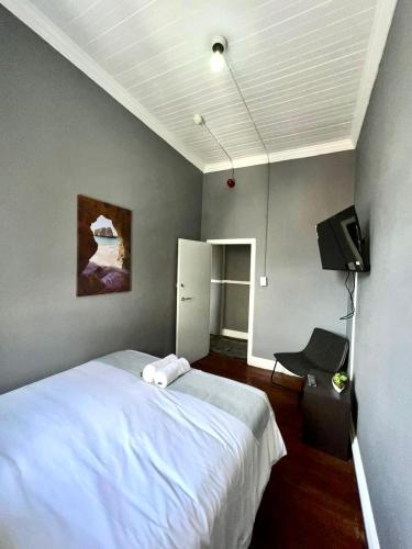 a bedroom with a white bed and a television at CapePod Sea Point in Cape Town