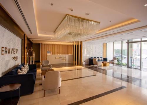 a living room with a blue couch and chairs at High Floor 31 with Skyline View in Manama