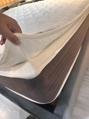 a person is making a mattress on a machine at VIP Luxury Premium Apartment in Manama