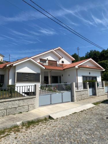 a white house with a fence in front of it at Casinhas Dona Isabel in Arcos de Valdevez