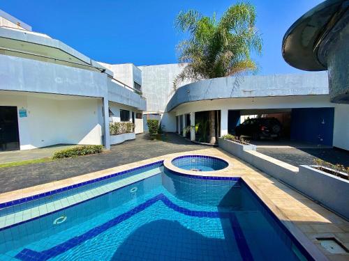 a swimming pool in front of a house at Casa Alto Padrão de Frente ao Mar in Peruíbe