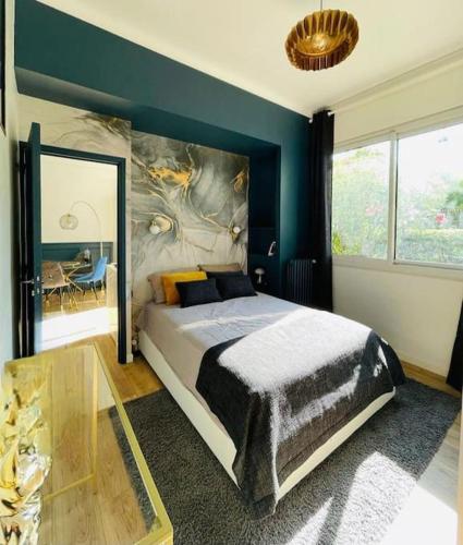 une chambre avec un grand lit et un mur bleu dans l'établissement Luxueux appartement, Carré d'Or, Square Mozart, à Nice